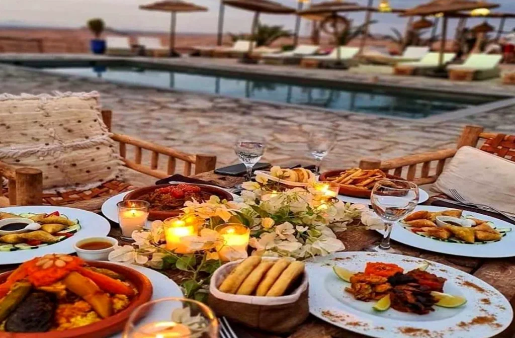 Moroccan dinner table with candles beside the pool of a desert camp
