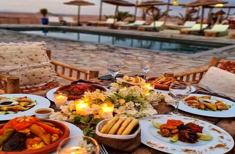 Moroccan dinner table with candles beside the pool of a desert camp