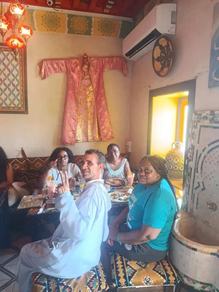 Travellers sharing lunch in a traditional room with painted woodwork