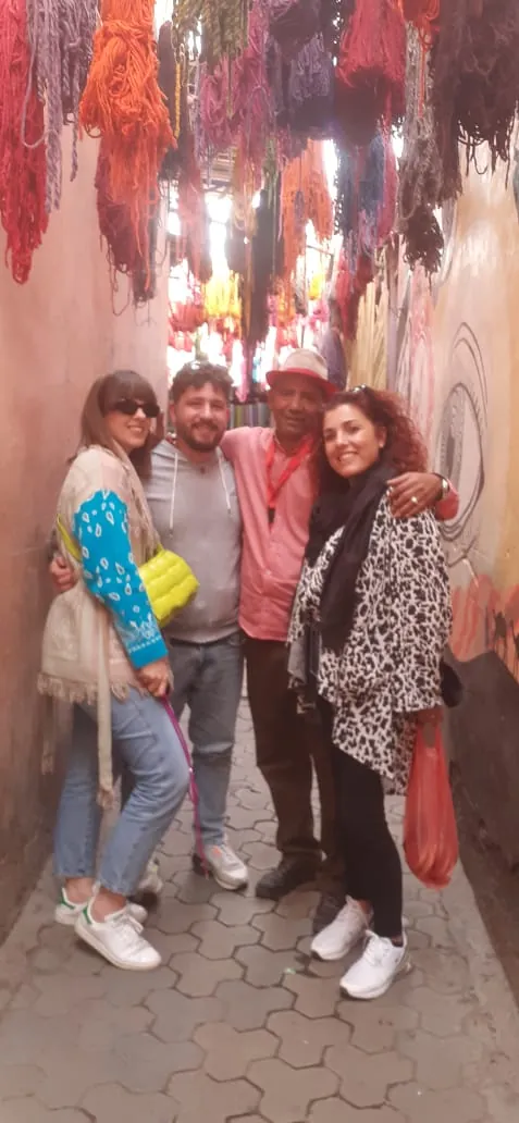Visitors under hanks of dyed wool in the dyers souk of Marrakech