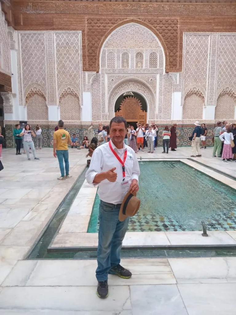 Local guide standing by the courtyard pool of Ben Youssef Madrasa