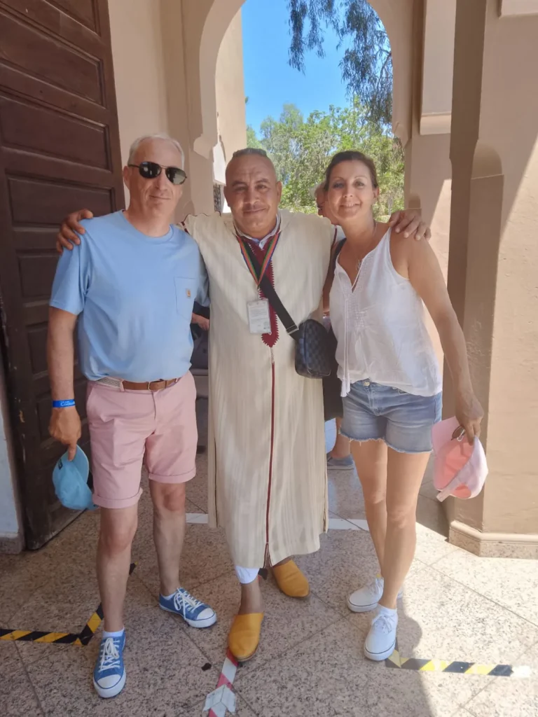 Couple with their guide in a shaded doorway in Marrakech