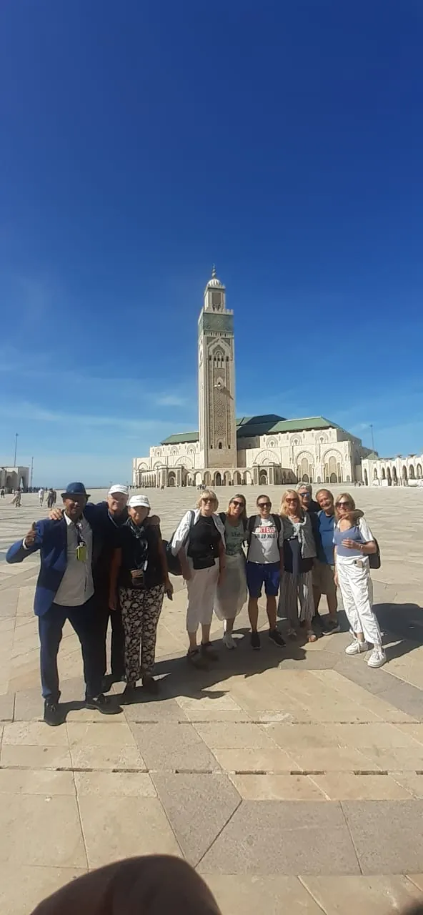 Travellers in front of the Hassan II Mosque minaret in Casablanca