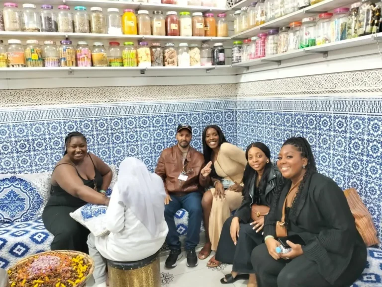 Women travellers seated in a tiled herbalist shop in the medina