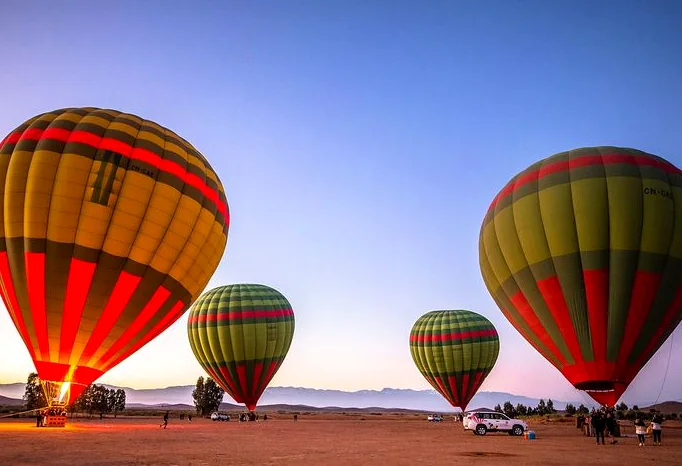 Hot air balloons inflating on a plain near Marrakech at dawn