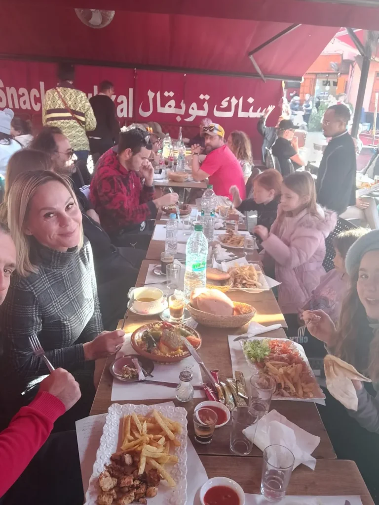 Group sharing grilled food at a Jemaa el-Fna food stall