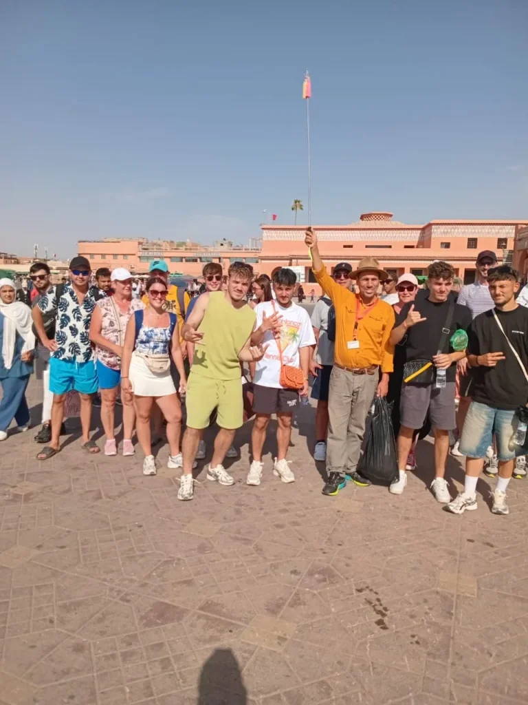 Large tour group gathered on Jemaa el-Fna square in the late afternoon