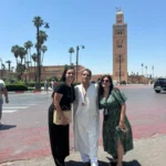 Two women travellers with their guide on the square below the Koutoubia