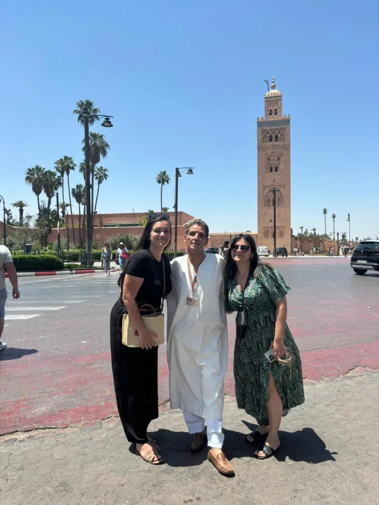 Two women travellers with their guide on the square below the Koutoubia