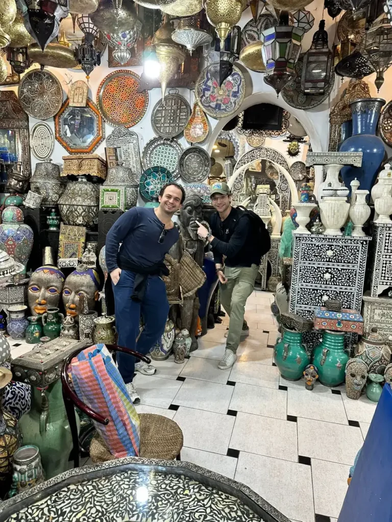 Metal lanterns and painted ceramics filling a shop in the Marrakech souks