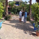 Guide and visitors on a tiled garden path in the Majorelle Garden