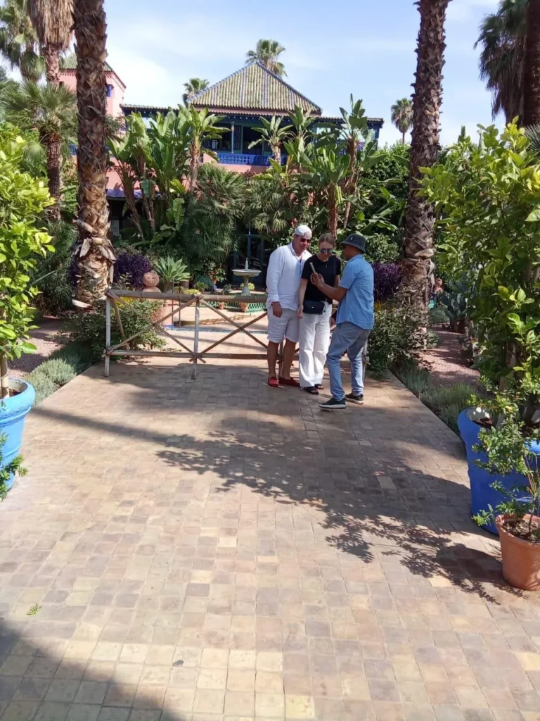Guide and visitors on a tiled garden path in the Majorelle Garden