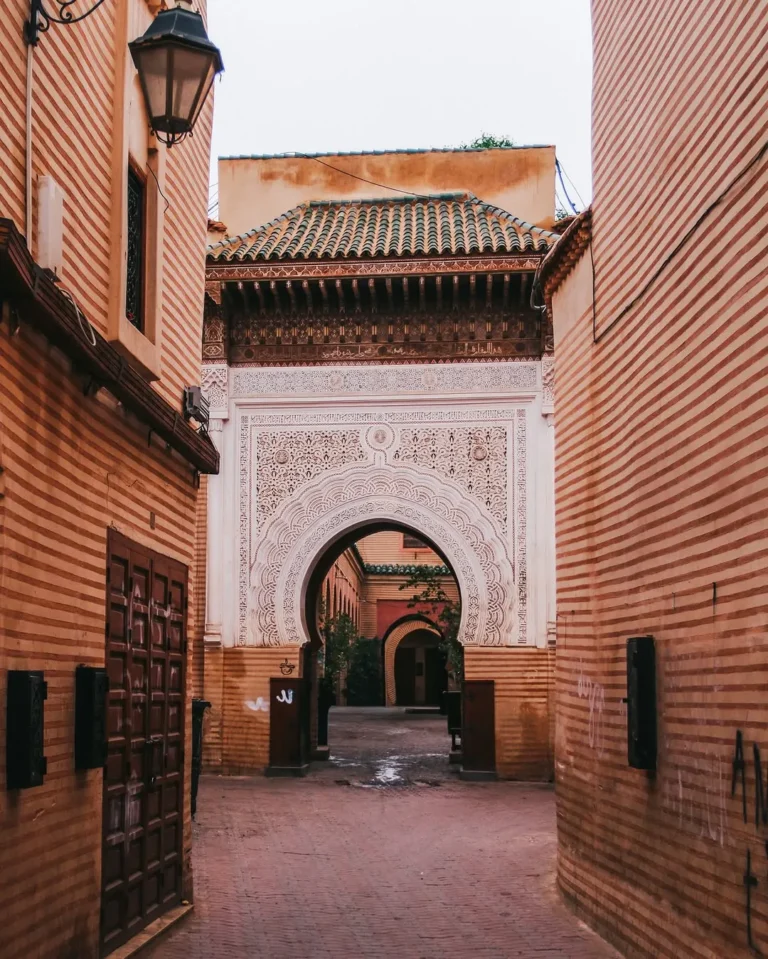Medina lane leading to a carved stone archway in Marrakech