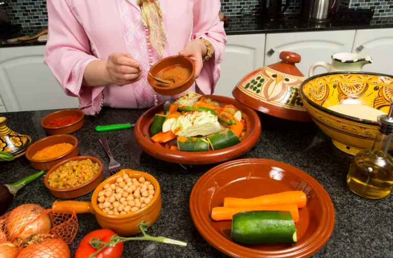 Spices, vegetables and a tagine laid out for a Moroccan cooking class