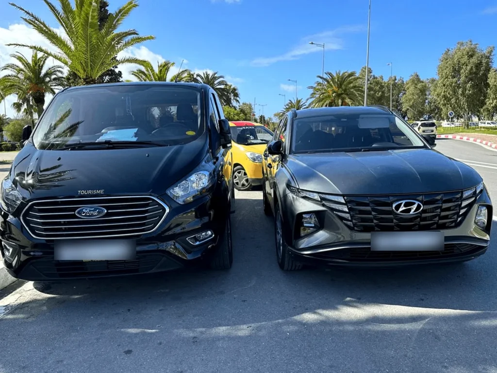 Black minivan and SUV parked side by side on a sunny street