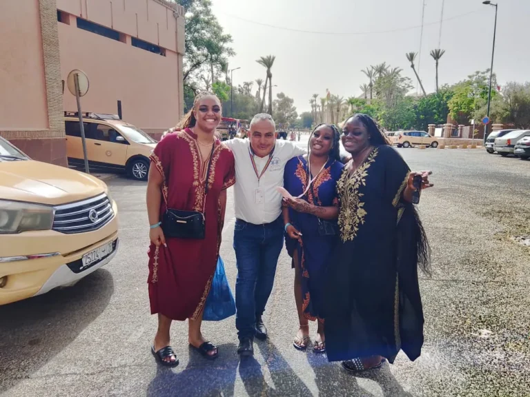 Travellers meeting their driver beside a car on a Marrakech street