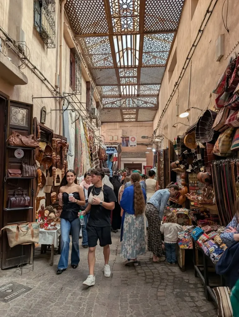 Shoppers in Souk Semmarine under a carved wooden lattice roof