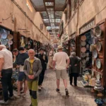 Shoppers in a covered souk street lined with ceramics