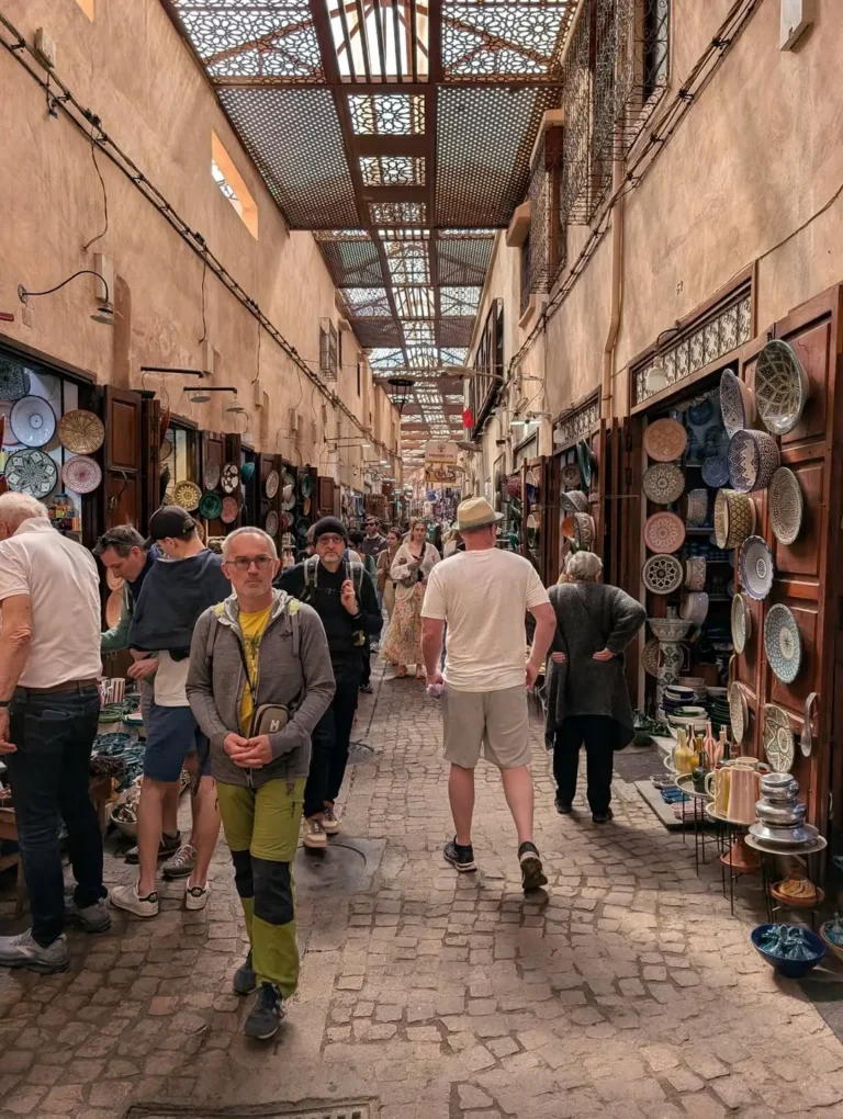 Shoppers in a covered souk street lined with ceramics